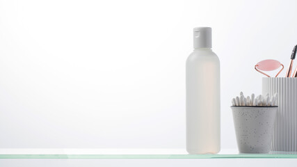 A bottle with a natural cosmetic product on a glass shelf. Copy space
