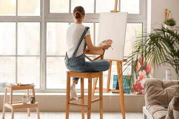 Female artist painting picture in  workshop