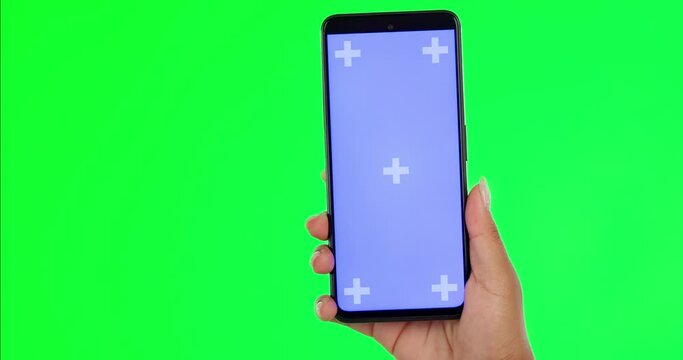 Woman, hands and phone on green screen for social media advertising against a studio background. Hand of female person with mobile smartphone app display, mockup or tracking markers for advertisement
