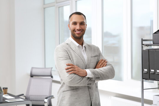 Smiling young businessman in his modern office