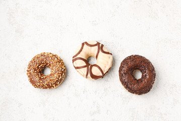 Sweet chocolate donuts on light grunge background