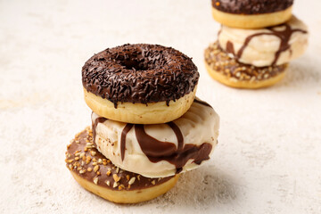Sweet chocolate donuts on light grunge background