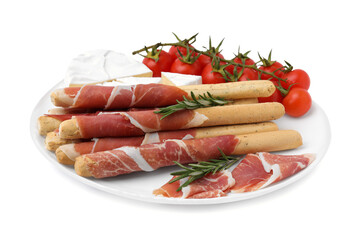 Plate of delicious grissini sticks with prosciutto, tomatoes and cheese on white background