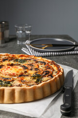 Delicious quiche with mushrooms and knife on table, closeup