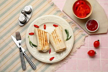 Plate with tasty shawarma and chilli on pink tile table