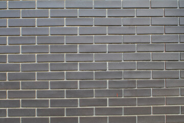 Black and grey brick wall texture interior or exterior design backdrop, vintage dark tone. Blank copy space.