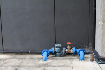 Blue water meter and valve supply pipe with joint on cement floor. Plumber installing water equipment. Measuring device to check counter number of water. 