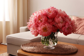 Beautiful pink peonies in vase on table at home, space for text. Interior design