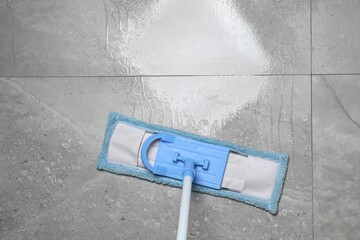Cleaning grey marble floor with mop indoors, top view. Space for text