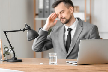 Glass of water with soluble tablet on table in office, closeup