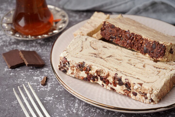 Plate with pieces of tasty marble halva on grunge background