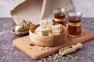 Pieces of tasty marble halva and glasses with Turkish tea on table