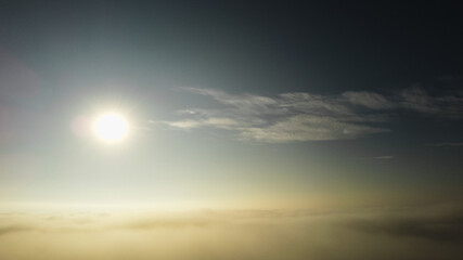 Golden Horizon: Captivating Aerial View of the Sun on Clouds of Mist at Sunset
