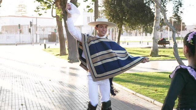 mixed group of four people dressed as huaso dancing cueca in the town square of La Serena