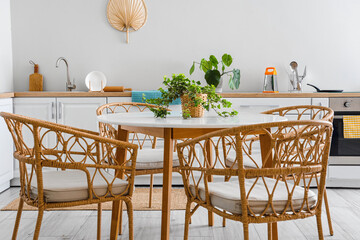 Interior of light kitchen with dining table and white counters