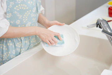 お皿を洗う女性の手元