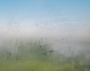 Condensation on clear glass window in panoramic bathroom or shower room. Water drops and condensed...