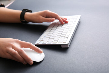 Obraz na płótnie Canvas Female programmer using computer keyboard with mouse on dark background, closeup