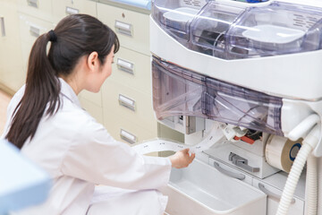 Fototapeta premium 薬局・ドラッグストアで自動分包機を使って粉薬・調剤・処方箋を作る薬剤師 