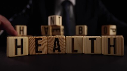 Hand flip wooden cube with word wealth to health.