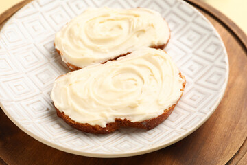 Plate of tasty sandwiches with cream cheese on table