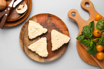 Plate of tasty sandwiches with cream cheese and tomatoes on grey background