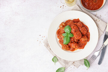 Plate of tasty meat balls with sauce on light background