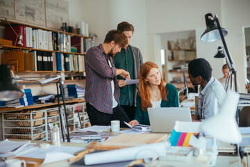 Group of young architects working on a project together in the office