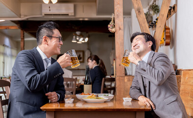 飲み会で盛り上がって爆笑するビジネスマン

