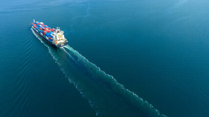 Aerial stern view of cargo maritime ship with contrail in the ocean ship carrying container and running for export concept technology freight shipping by ship forwarder mast