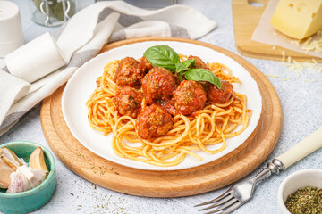 Plate of boiled pasta with tomato sauce and meat balls on white table