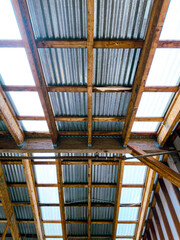 Obraz premium rafters ceiling light machine shop workshop factory roof corrugated beams shed metal tin wood beams