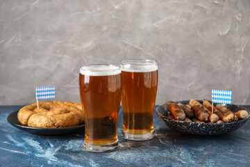 Glasses of cold beer and tasty sausages on table. Oktoberfest celebration