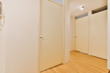 an empty room with wooden floors and white doors on either side, one door open to the other is closed