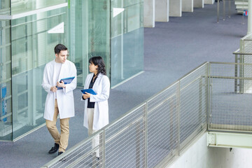 Multinational group walking in the lobby wearing white coats.