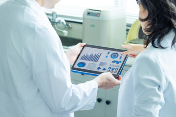 Group of researchers looking at tablet data in the lab. Research and Development.