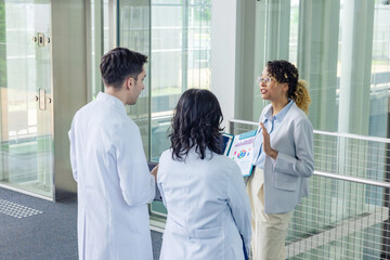 A multinational group having a conversation in the lobby.
People in white coats and sales staff....