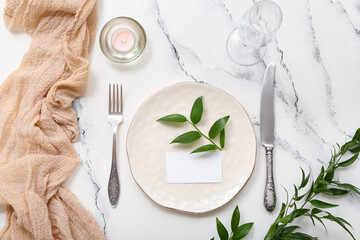 Beautiful table setting with blank invitation card and plant branches on white table