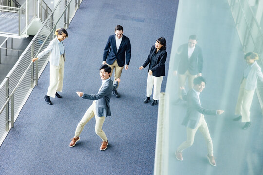 Multinational business group dancing in lobby. Success of business. High angle view.