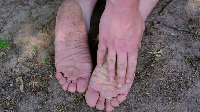 Extreme close up of bare sole or underfoot while touching or massaging with hand.
