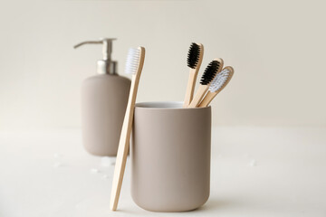 Bamboo tooth brushes in holder on light background