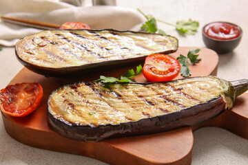 Board with delicious grilled eggplants, tomatoes and herbs on light background