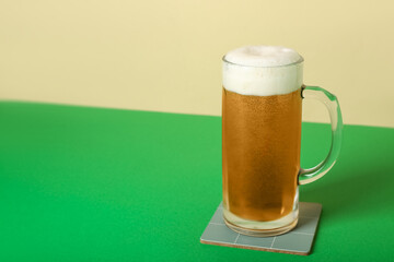Mug of cold beer on color background