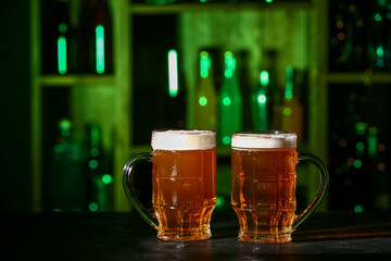 Mugs of fresh beer on table in bar