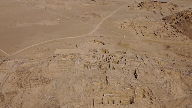 Aerial footage of ancient archaeological site called Caral. One of the oldest cities in the world. Drone flies backwards above the main and biggest pyramid. Located in the Supe Valley of Lima, Peru.