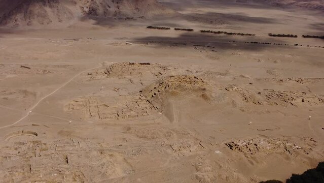 Aerial footage of the ancient UNESCO archaeological site of Caral. Drone zooms out of one of the stone pyramids. Recorded in 4k quality. Located in the Supe valley of Lima, Peru.