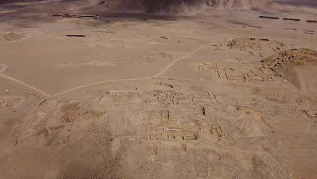 Aerial footage of the main pyramid or temple in the ancient city of Caral. The oldest in the Americas. Drone flies forward while tilting camera down. Located in the Supe valley of Lima, Peru.