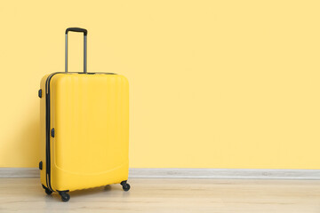 Suitcase near yellow wall. Travel concept