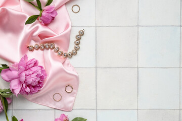 Composition with stylish female accessories and beautiful peony flowers on light tile background