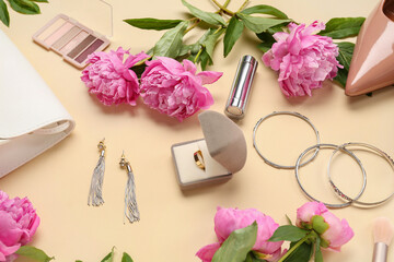 Composition with beautiful engagement ring, stylish accessories, cosmetics and peony flowers on color background